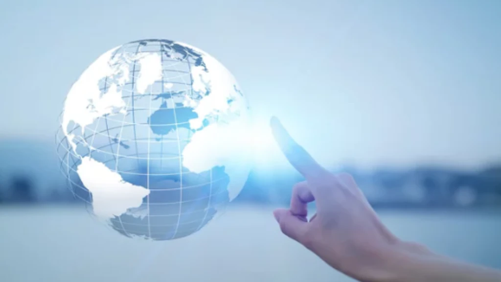 Une main pointe son index vers un globe transparent suspendu dans les airs.