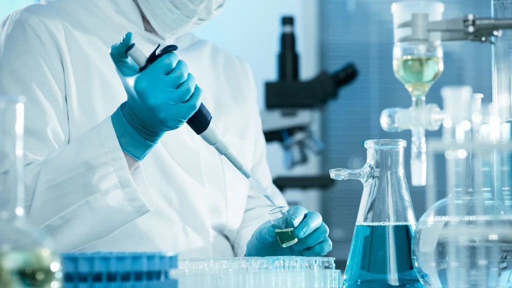 Ein Chemielaborexperte füllt mit der Pipette ein Reagenzglas ab.