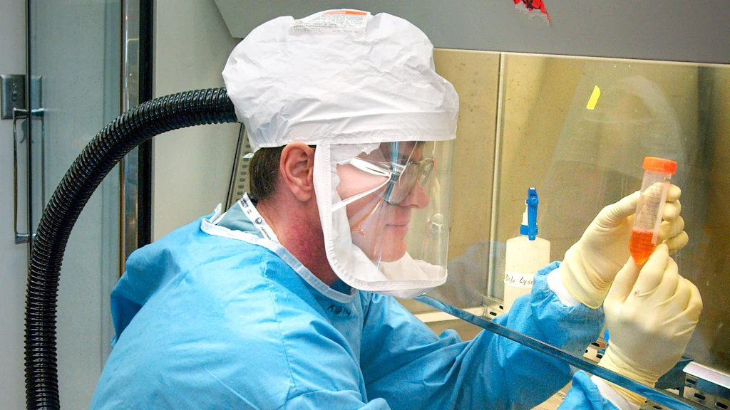Un technicien de laboratoire de chimie en tenue de protection au travail.
