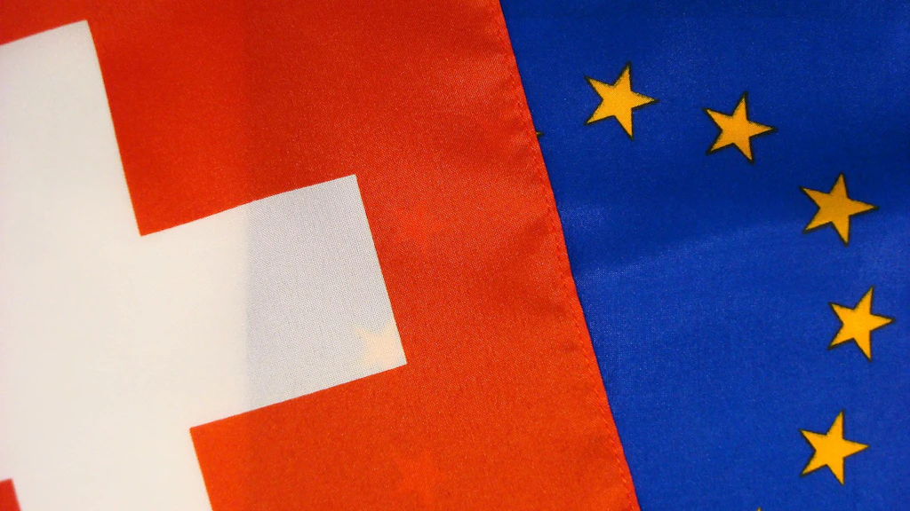 Eine EU und eine Schweizer Flagge, die die Handelsbeziehung symbolisieren