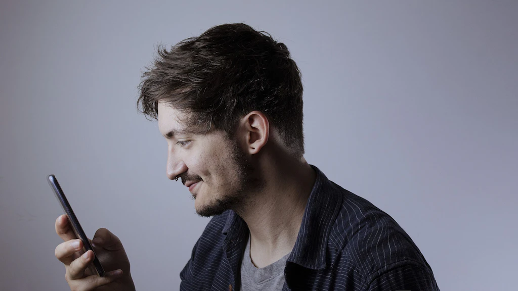 Ein Mann schaut auf sein Mobiltelefon