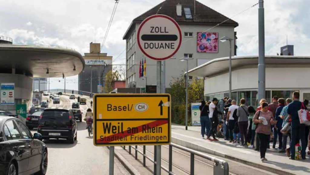 Cars and people are crossing the border at the border crossing in Weil am Rhein between Switzerland and Germany.