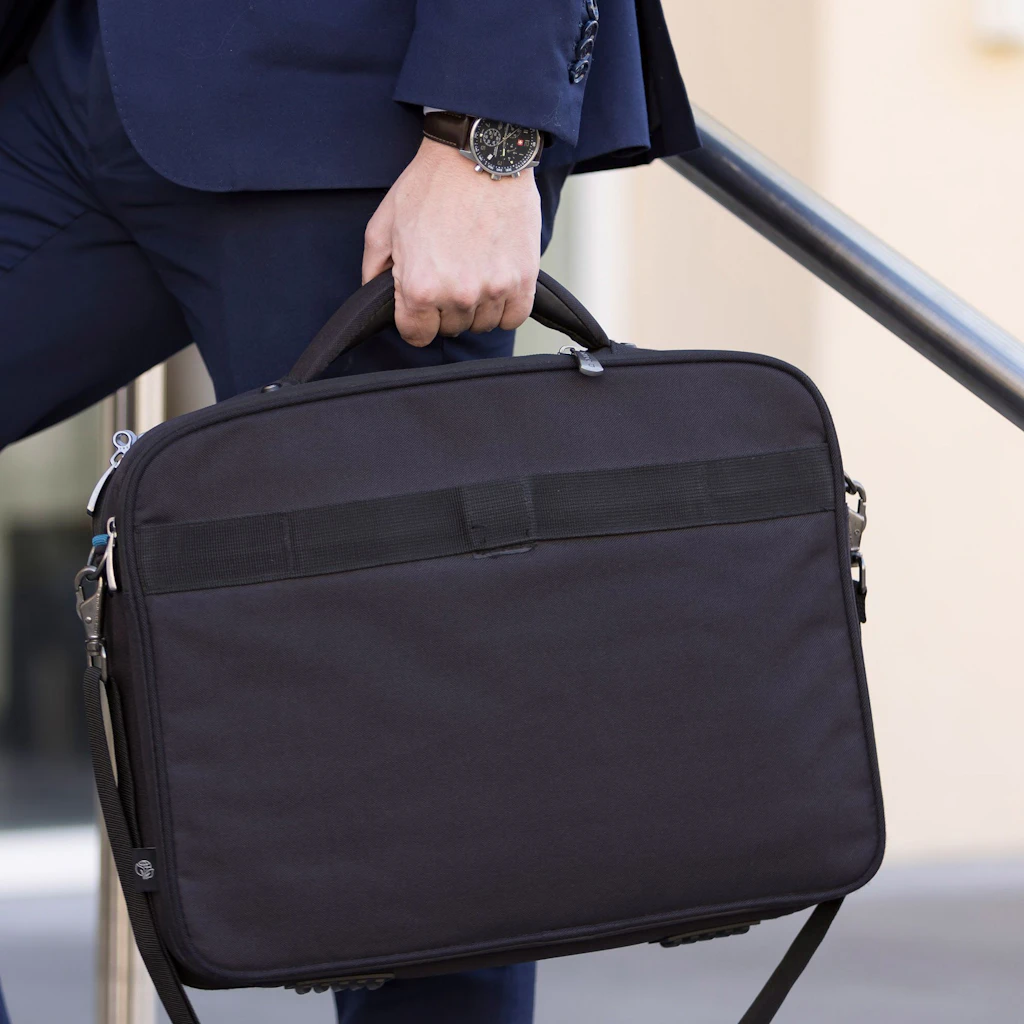 A man is carrying a black briefcase as he climbs the stairs
