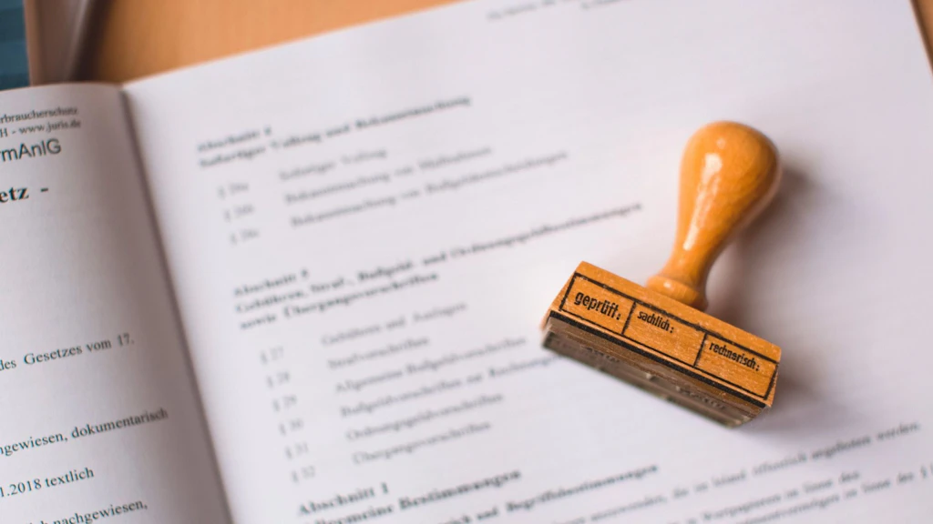 A wooden stamp rests on an open document with printed text.