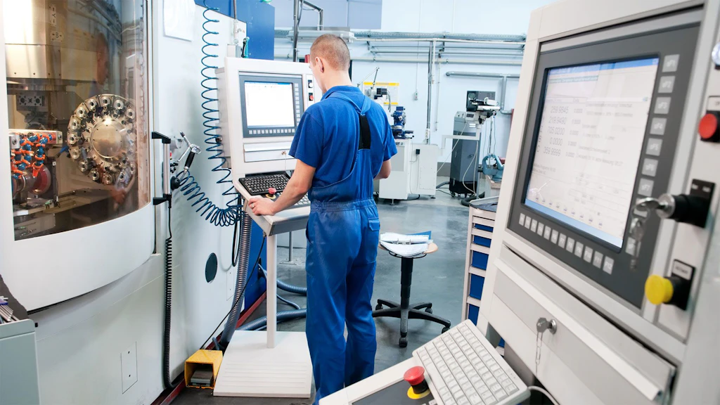 Young worker operating a CNC machine