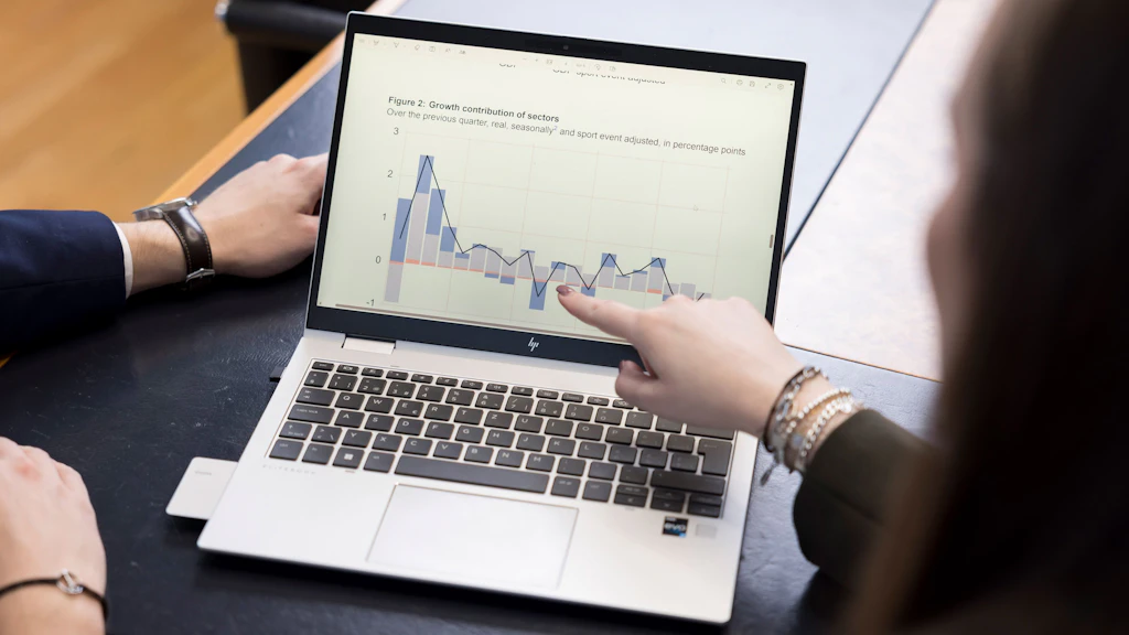 Two people are discussing a result on the screen