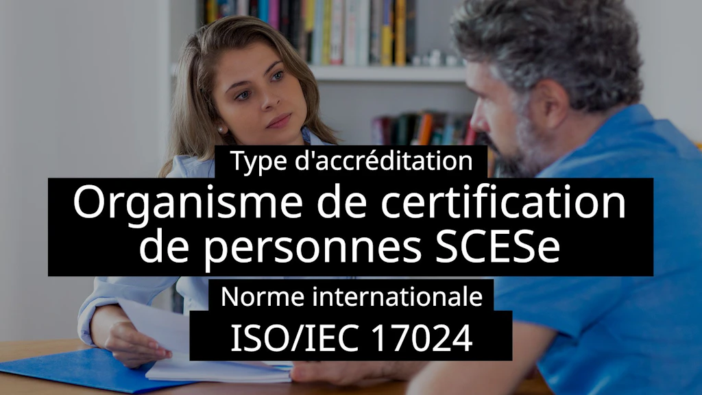 Une femme et un homme assis en train de discuter, des documents à la main – une bibliothèque en arrière-plan