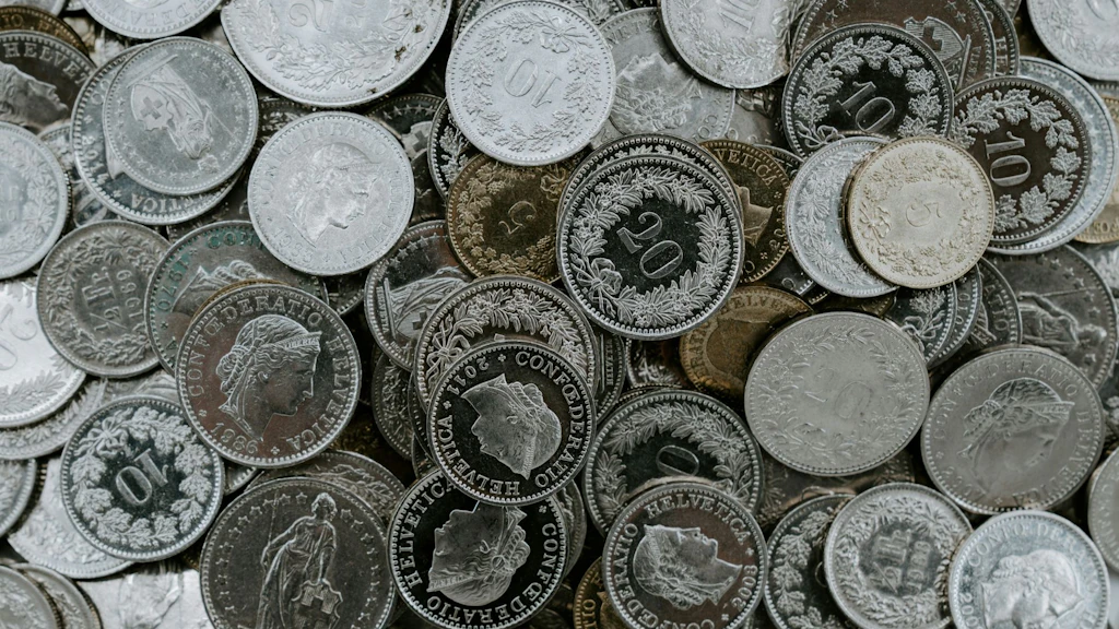L’image montre une collection de pièces de monnaie suisses.