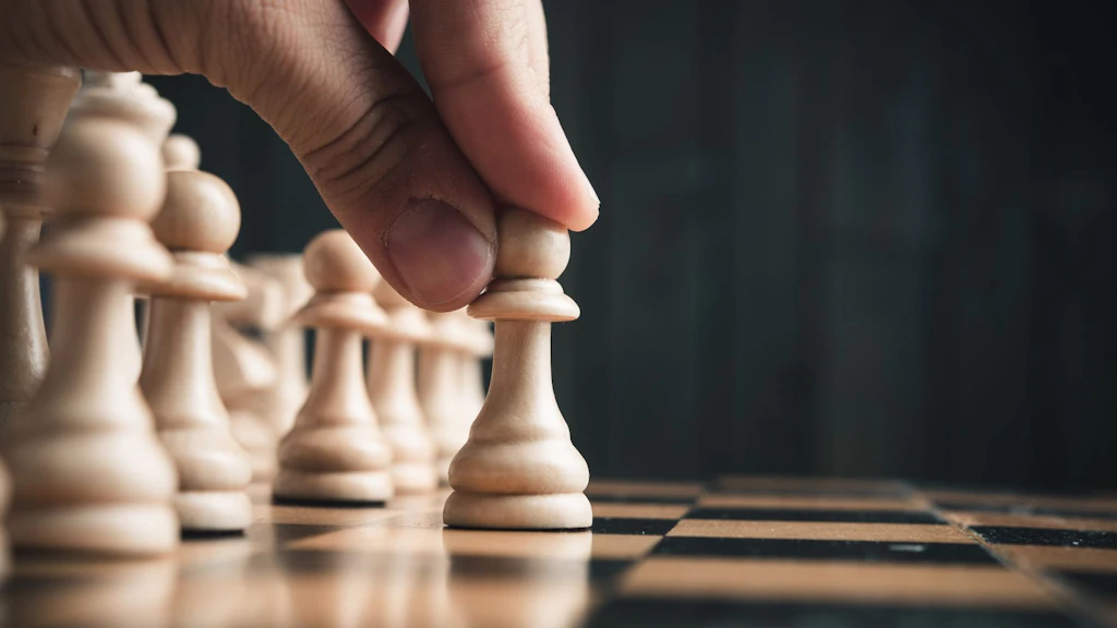 Une main déplaçant une pièce d'échecs sur l'échiquier.