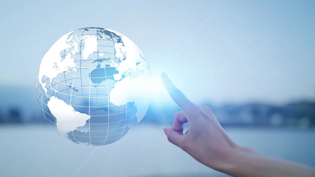 Une main pointe son index vers un globe transparent suspendu dans les airs.