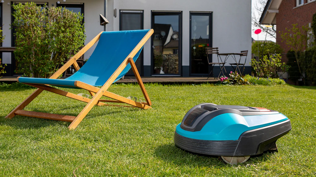 Un robot tagliaerba accanto a una sdraio in giardino.